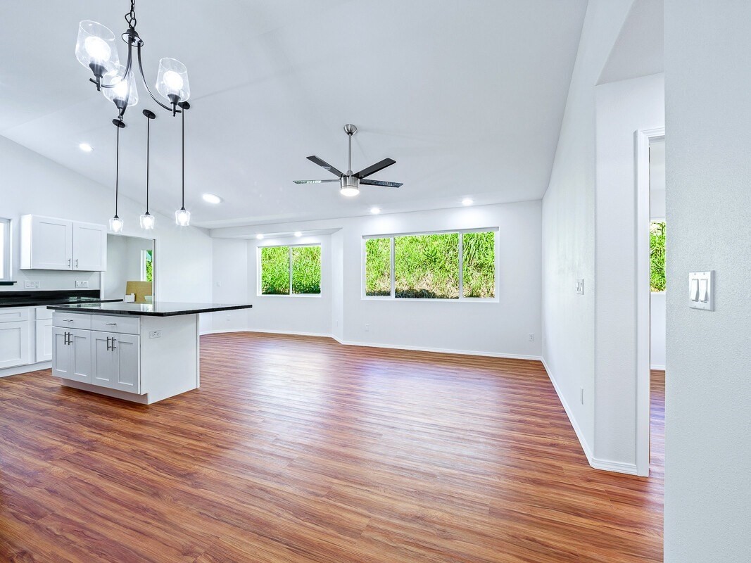 Peleke Road Mountain View, HI 96771 - Photo 4 of 24 a view of an empty room and kitchen with wooden floor