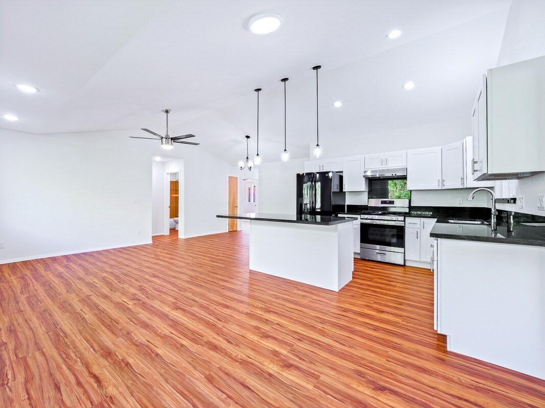 Peleke Road Mountain View, HI 96771 - Photo 5 of 24 a large kitchen with stainless steel appliances kitchen island granite countertop wooden floors