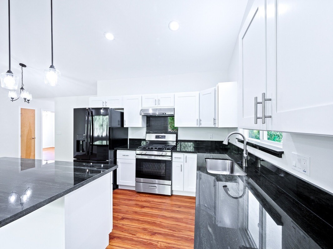 Peleke Road Mountain View, HI 96771 - Photo 6 of 24 a kitchen with stainless steel appliances a sink dishwasher a stove top oven a refrigerator and cabinets