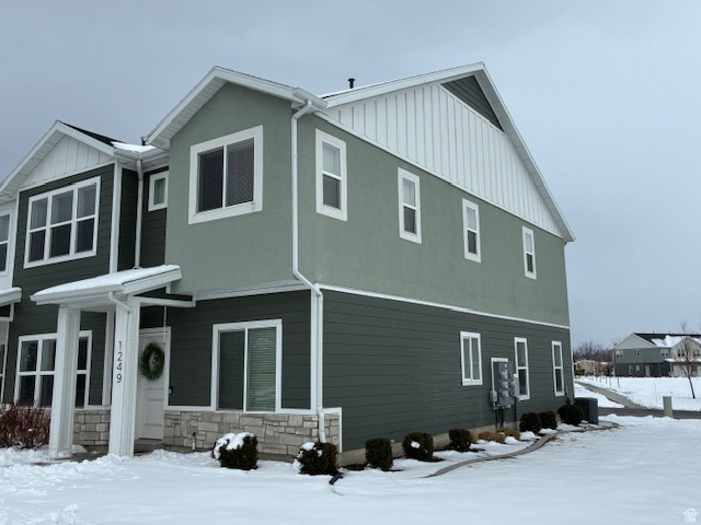 1249 West 1820th Street South Logan, UT 84321 - Photo 2 of 15 View of snowy exterior featuring stone siding, board and batten siding, and stucco siding
