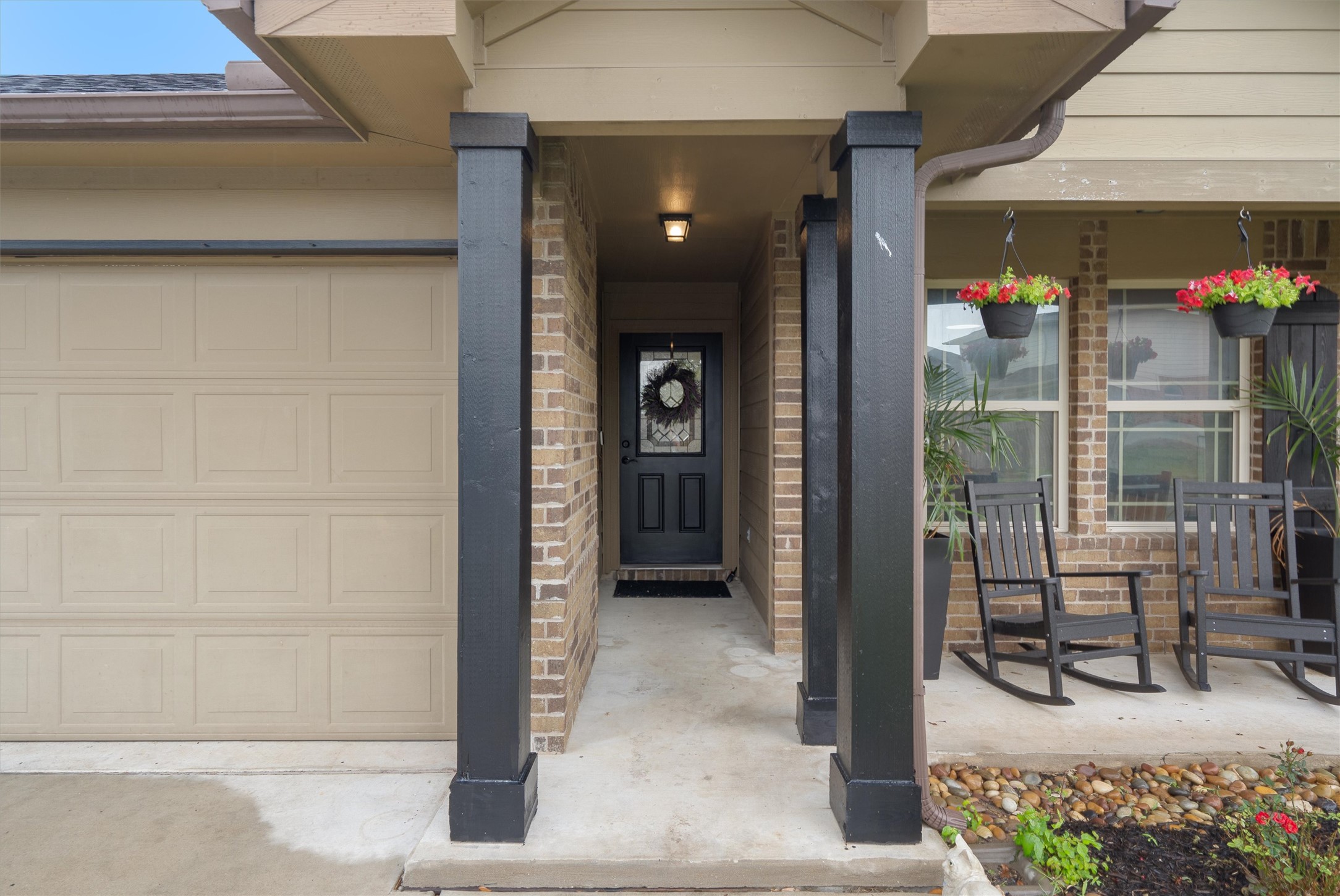 606 Old Peak Road Georgetown, TX 78626 - Photo 20 of 23 Welcoming front entryway featuring a covered porch, brick facade, and a beige panel garage door