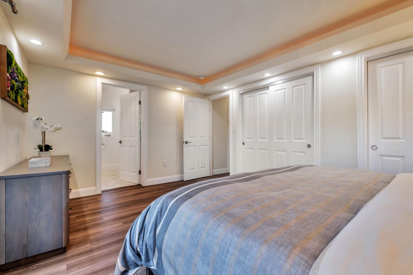 770 Graham Hill Road Santa Cruz, CA 95060 - Photo 40 of 83 a spacious bedroom with a bed and a chandelier