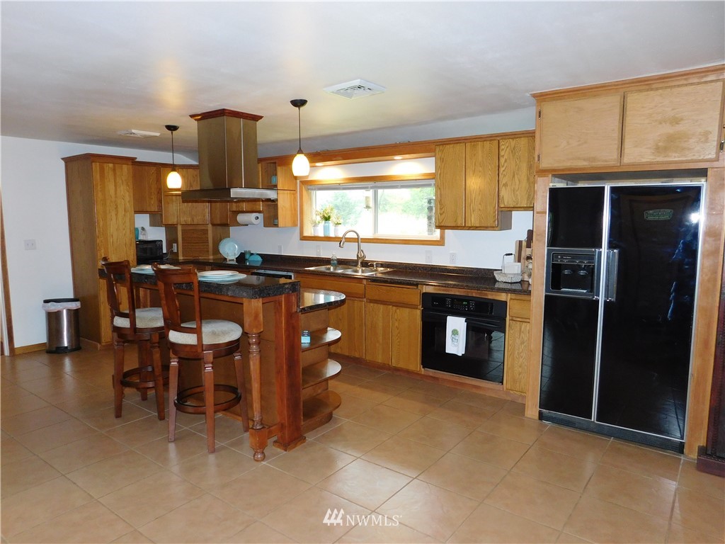 2902 Jackson Highway Chehalis, WA 98532 - Photo 9 of 32 a kitchen with stainless steel appliances granite countertop wooden cabinets a dining table and chairs