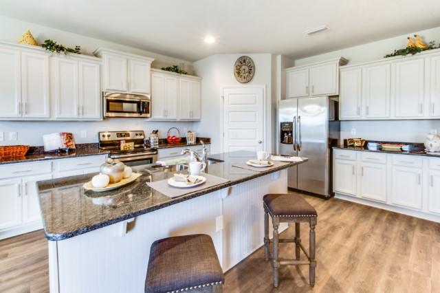 127 Hobson Avenue Crestview, FL 32539 - Photo 5 of 21 a kitchen with stainless steel appliances granite countertop a sink a stove a refrigerator a center island and chairs