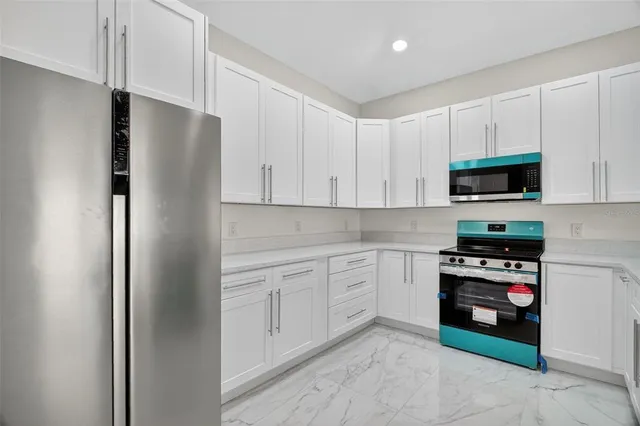 a kitchen with white cabinets and stainless steel appliances