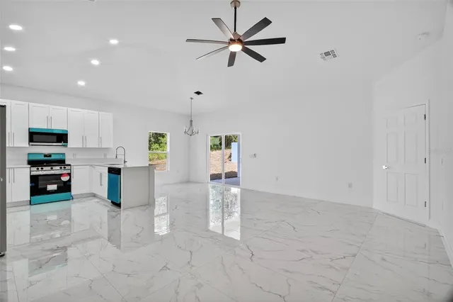 a view of kitchen with furniture and a ceiling fan