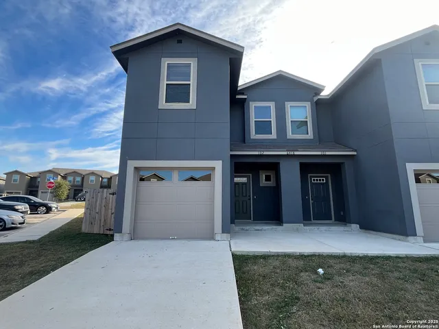a view of a house with a yard and garage