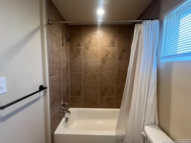 a bathroom with a sink a toilet a shower curtain and a bath tub