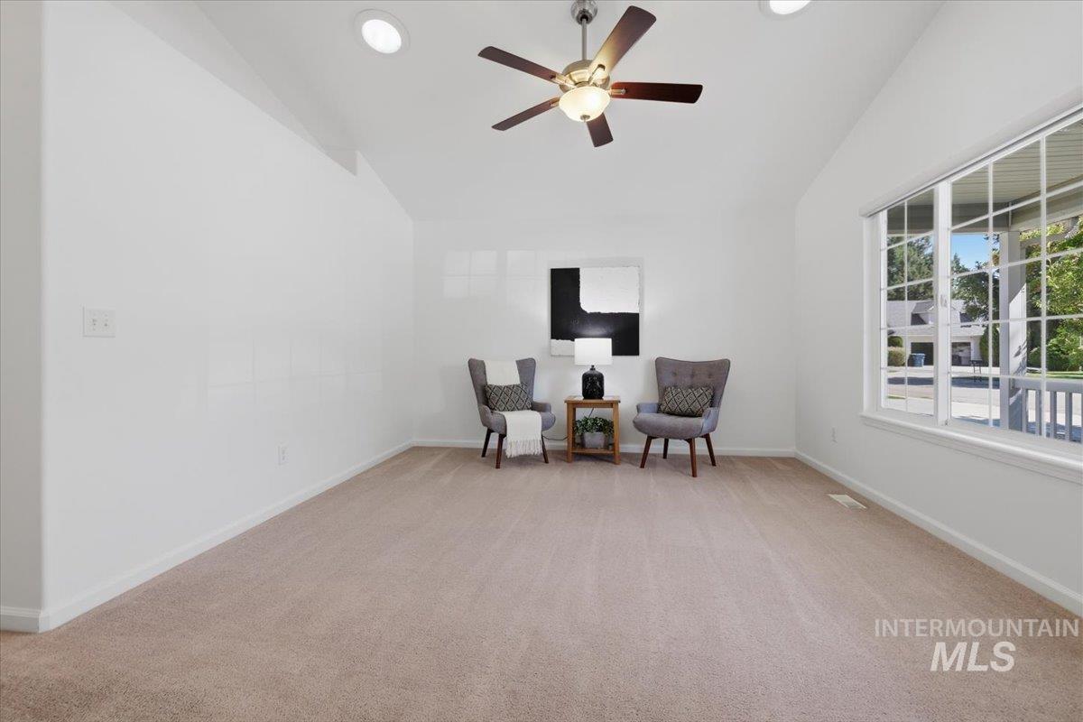 2075 North Springland Place Boise, ID 83713 - Photo 7 of 49 Vaulted ceiling room featuring light beige carpet, a ceiling fan with integrated lighting, recessed lighting, and a large multi-pane window