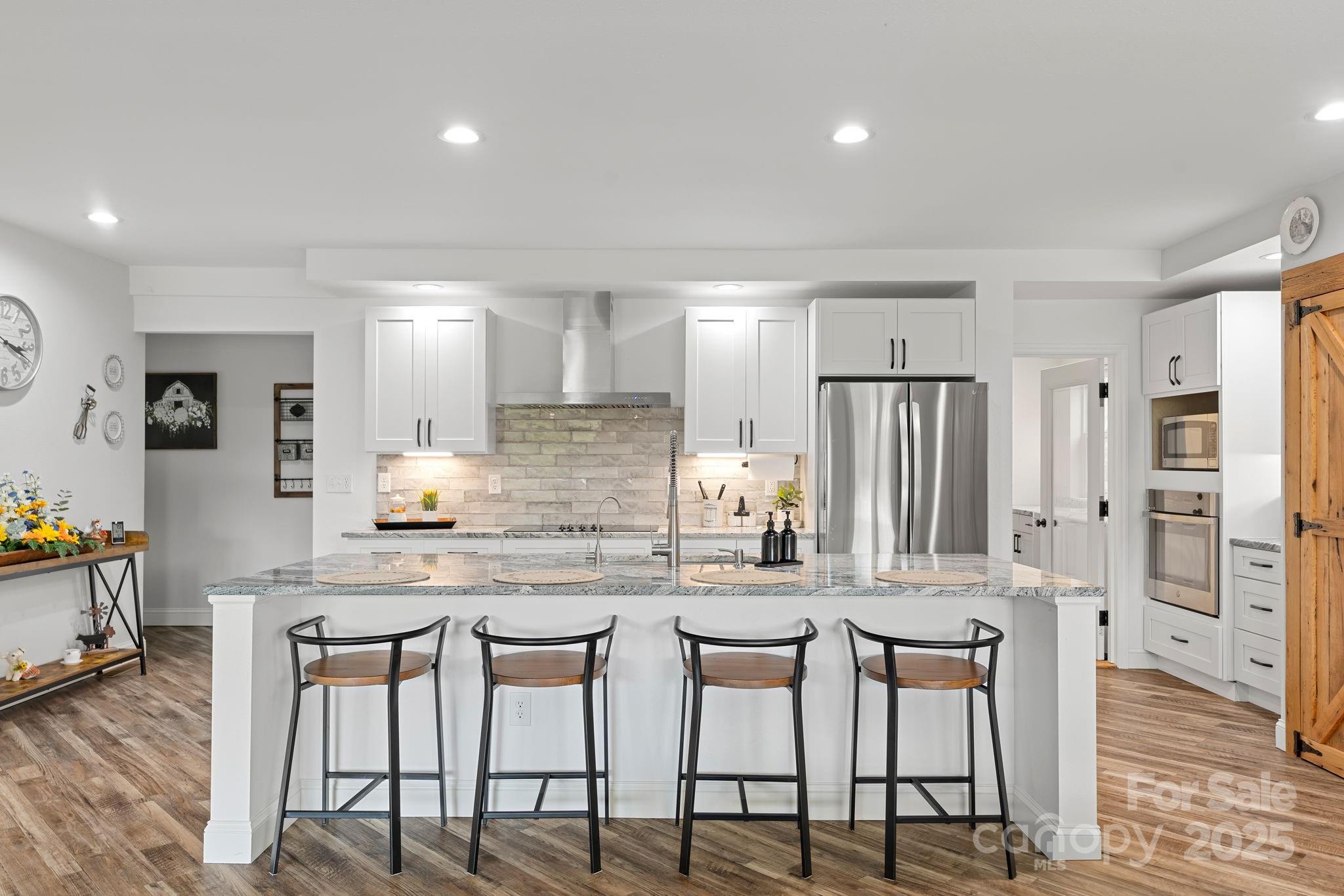 204 Mountain Spring Lane Canton, NC 28716 - Photo 11 of 45 a kitchen with stainless steel appliances kitchen island granite countertop a table and chairs