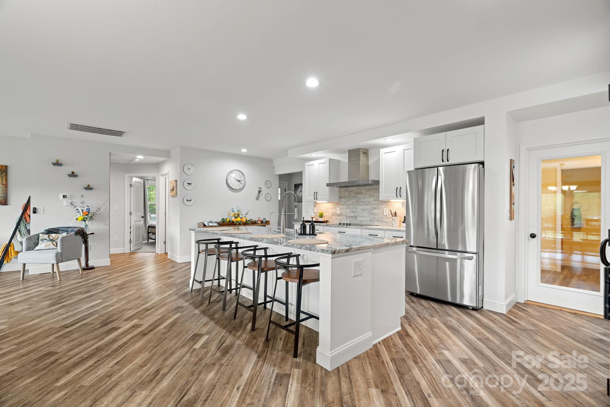 204 Mountain Spring Lane Canton, NC 28716 - Photo 12 of 45 a kitchen with stainless steel appliances granite countertop a refrigerator a stove a sink dishwasher and a dining table with wooden floor