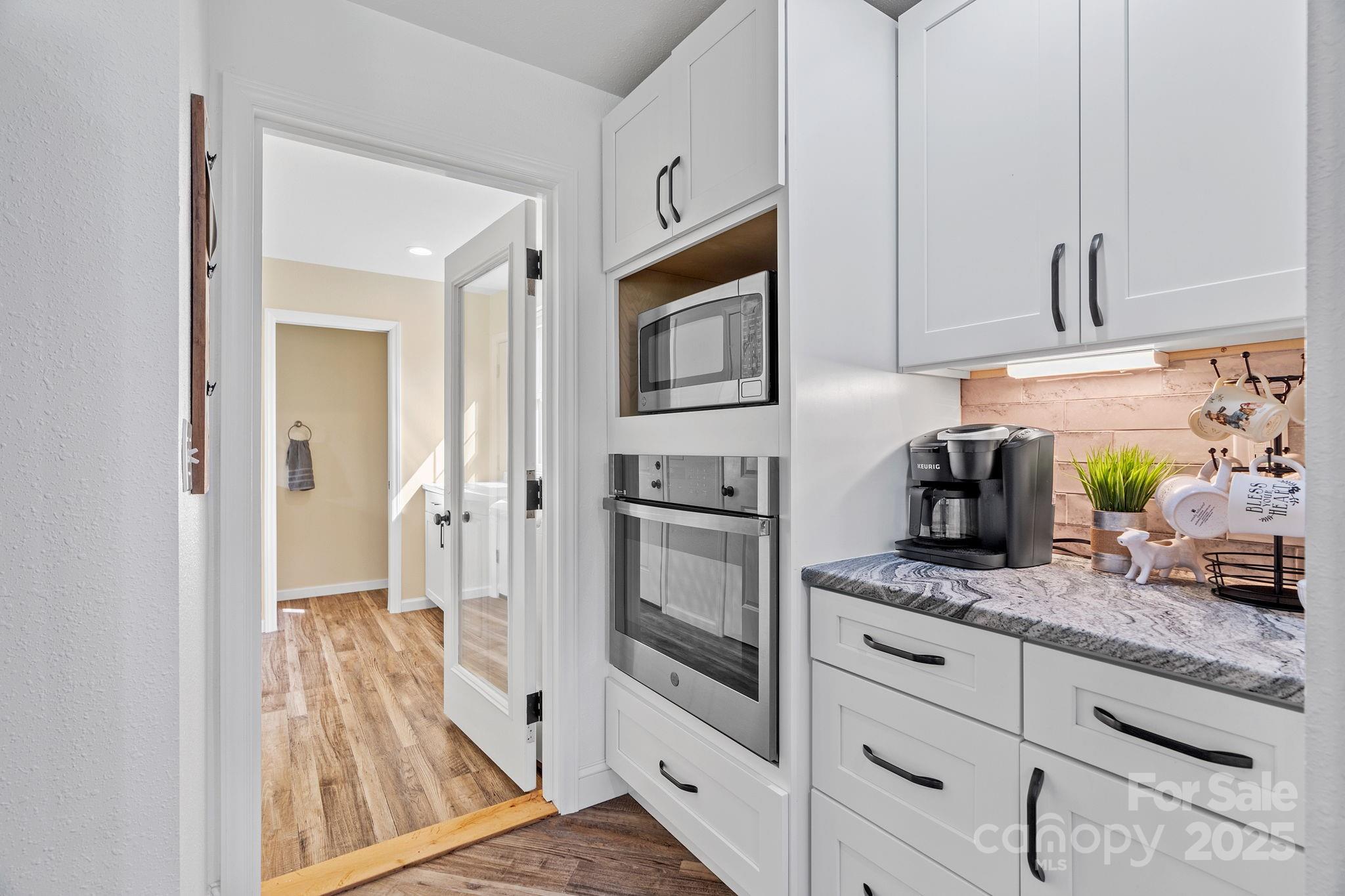 204 Mountain Spring Lane Canton, NC 28716 - Photo 16 of 45 a kitchen with granite countertop white cabinets and white appliances