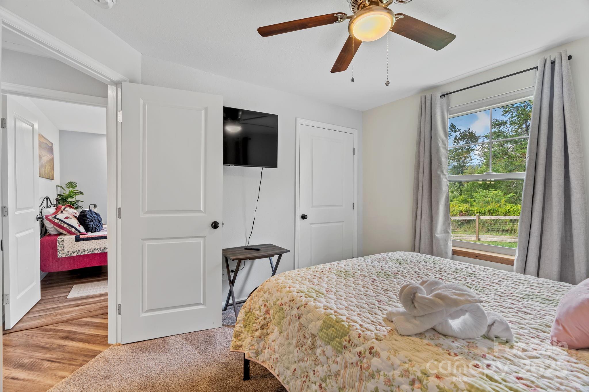 204 Mountain Spring Lane Canton, NC 28716 - Photo 31 of 45 a bedroom with a bed and a chandelier