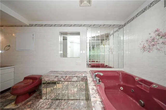 a spacious bathroom with a granite countertop tub sink and mirror