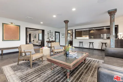 a kitchen with granite countertop center island a wooden floor stainless steel appliances and windows