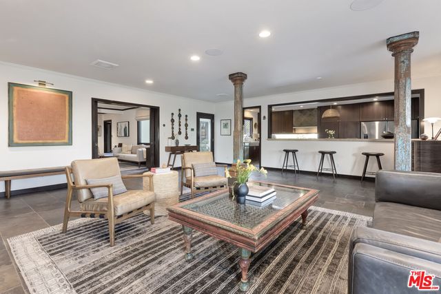 a kitchen with granite countertop center island a wooden floor stainless steel appliances and windows