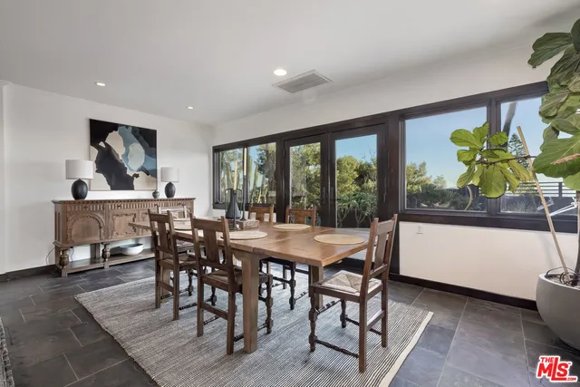 a dining room with furniture a rug and a floor to ceiling window