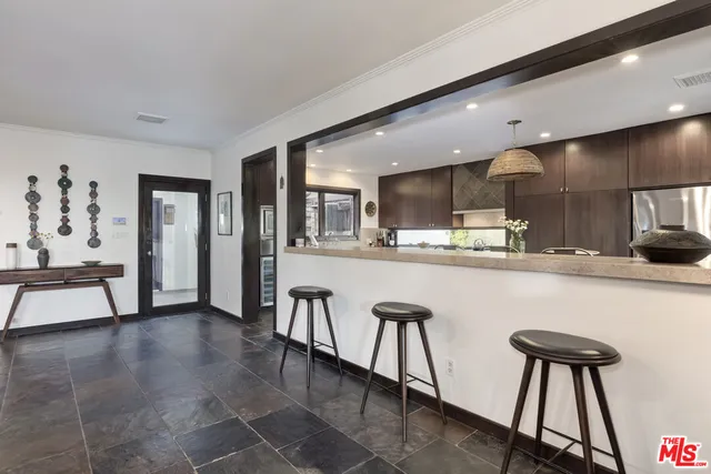 a kitchen with stainless steel appliances kitchen island granite countertop a refrigerator and a stove top oven