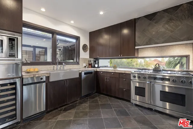 a kitchen with stainless steel appliances granite countertop a stove a sink and a microwave
