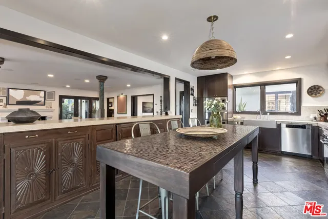 a kitchen with granite countertop center island a wooden floor stainless steel appliances and windows