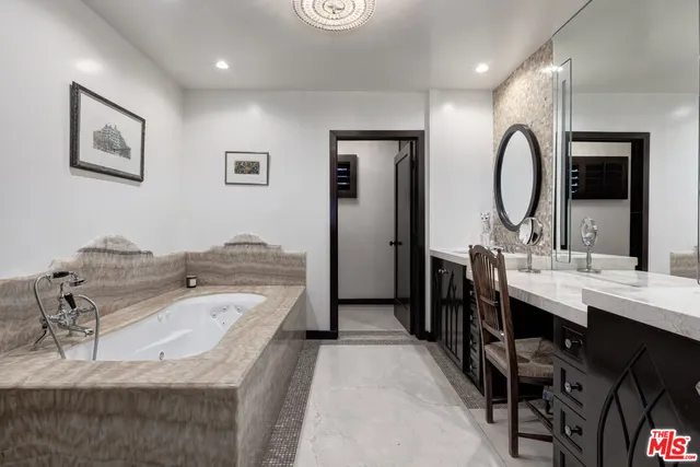 a en suite bathroom with a granite countertop double vanity sink a mirror and a shower