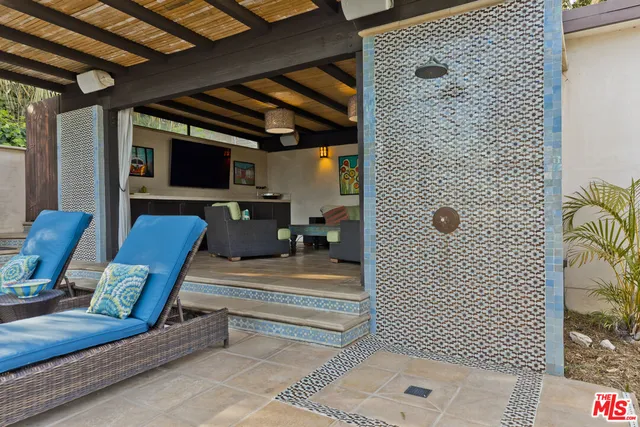 a living room with patio furniture and a floor to ceiling window
