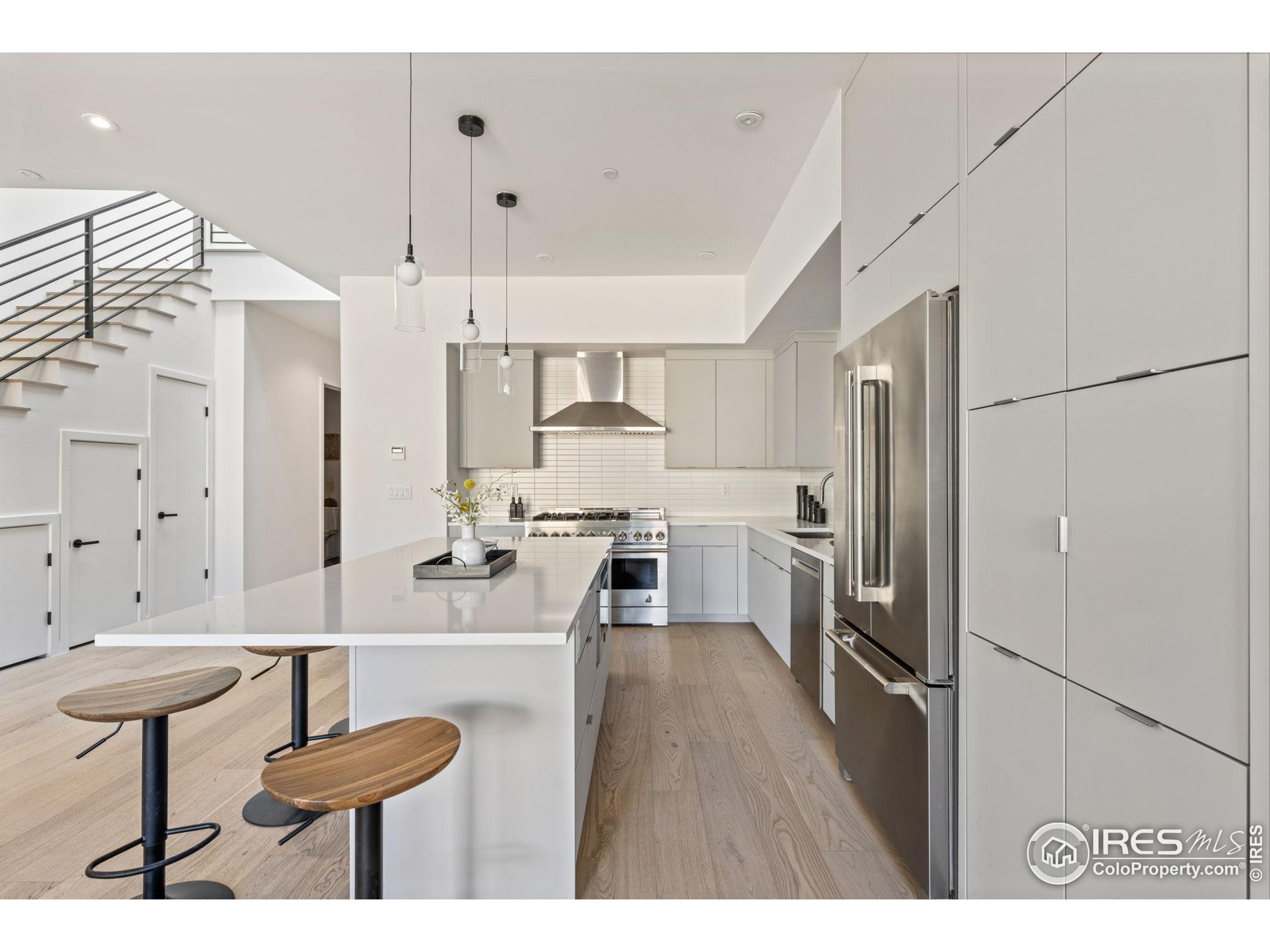 3315 Broadway Boulder, CO 80304 - Photo 3 of 42 a kitchen with stainless steel appliances a refrigerator a stove a sink dishwasher and white cabinets with wooden floor
