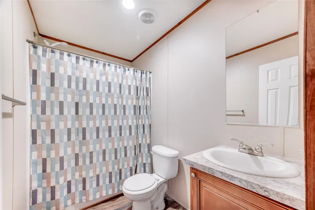 a bathroom with a granite countertop sink and a toilet