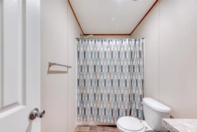 a white toilet sitting next to a shower curtain