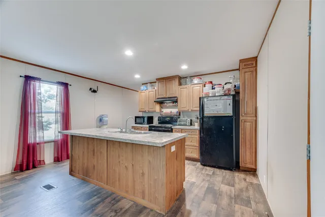 a kitchen with stainless steel appliances granite countertop a refrigerator and a sink