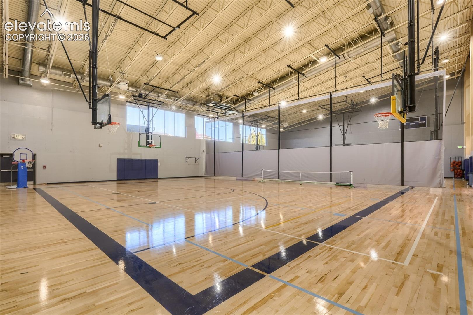 10149 Angeles Road Peyton, CO 80831 - Photo 22 of 24 Full-size gymnasium featuring a hardwood court, multiple basketball hoops, high ceilings.