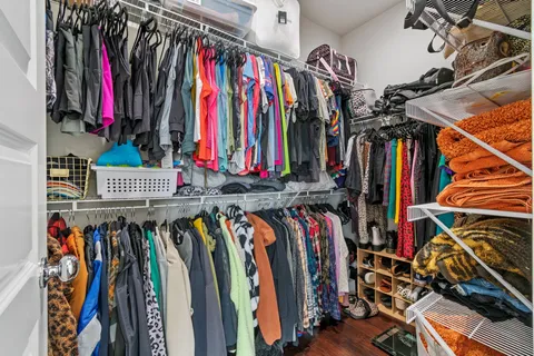 a view of walk in closet with clothes