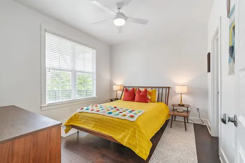 a bedroom with a bed lamps and a dresser