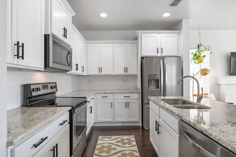 a kitchen with stainless steel appliances granite countertop a sink stove and refrigerator