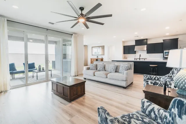 a living room with stainless steel appliances kitchen island furniture and wooden floor