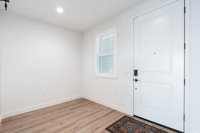 a view of an empty room with wooden floor