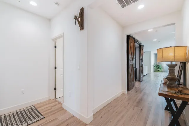 a view of a hallway with wooden floor and workspace