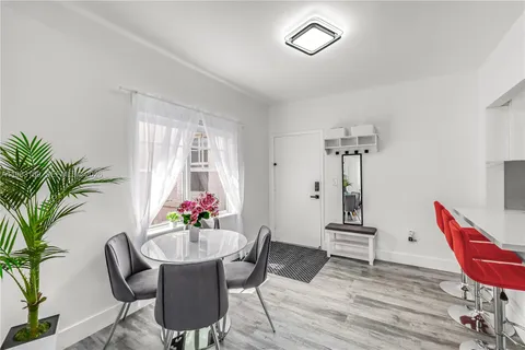 a dining room with furniture potted plants and wooden floor