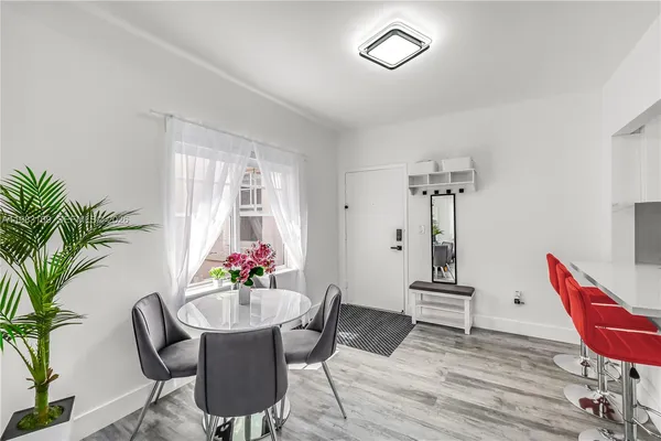 a dining room with furniture potted plants and wooden floor