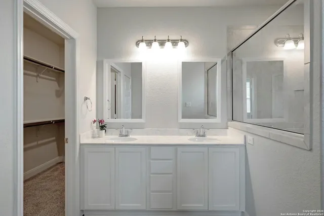 a bathroom with a double vanity sink and a mirror