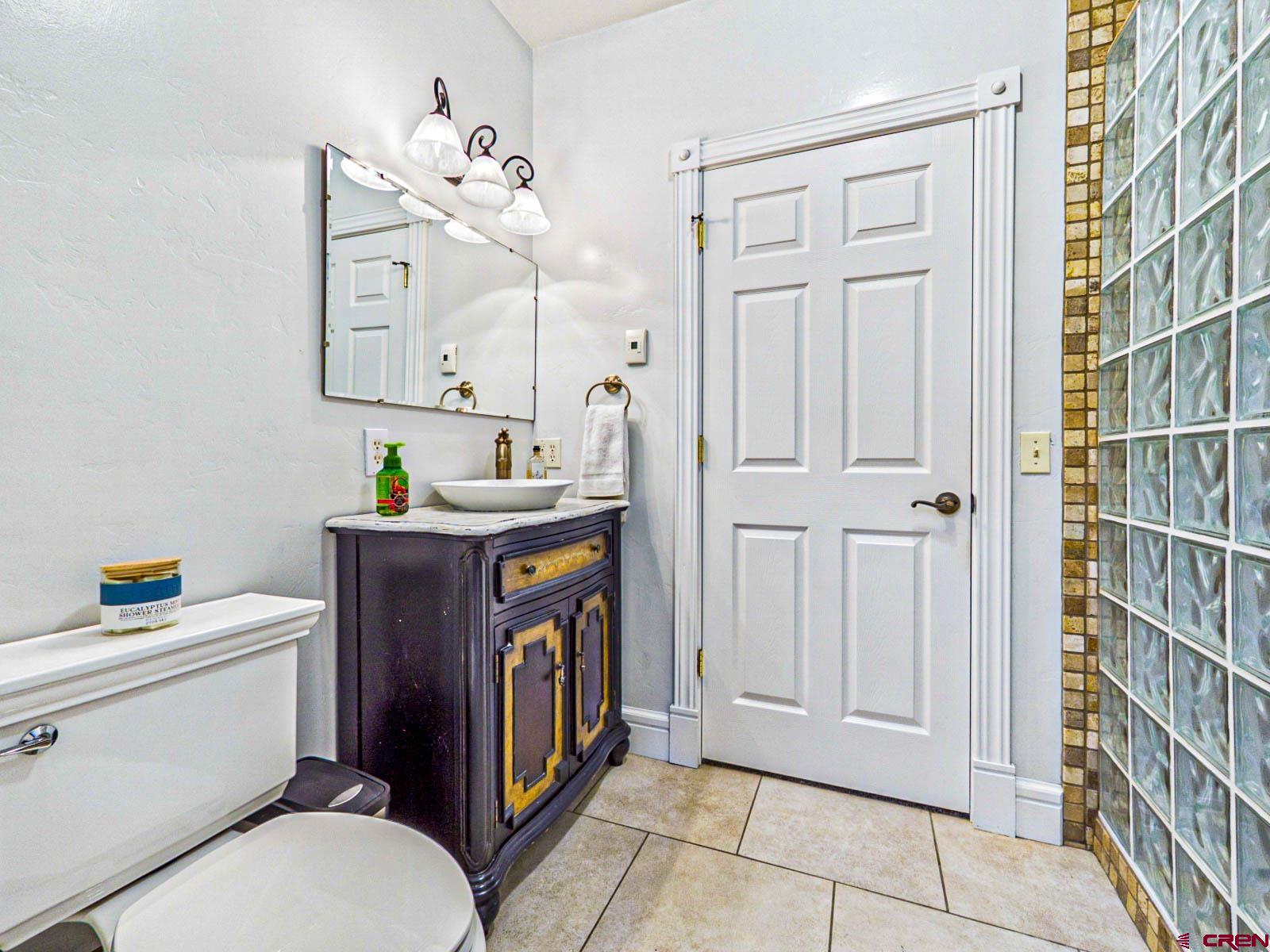 16331 2550th Road Cedaredge, CO 81413 - Photo 21 of 45 a bathroom with a toilet sink vanity and mirror