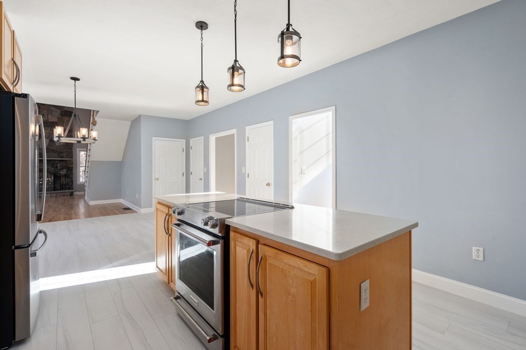 41 Mockingbird Hill Road Windham, NH 03087 - Photo 11 of 36 a kitchen that has a sink a microwave oven a stove and white cabinets with wooden floor