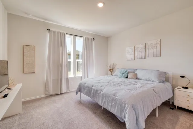 a bedroom with a bed and a window