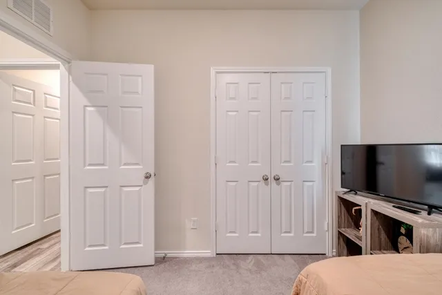 a bedroom with a flat screen tv and dresser