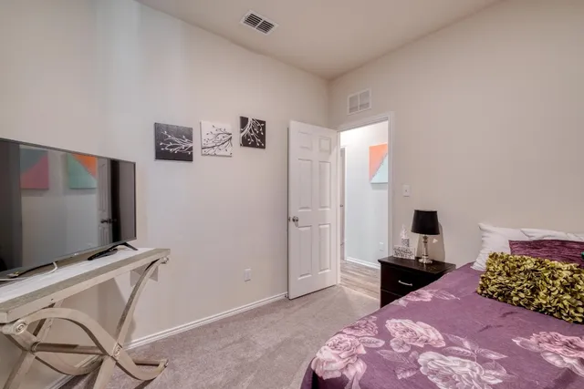 a bedroom with a bed and a flat screen tv