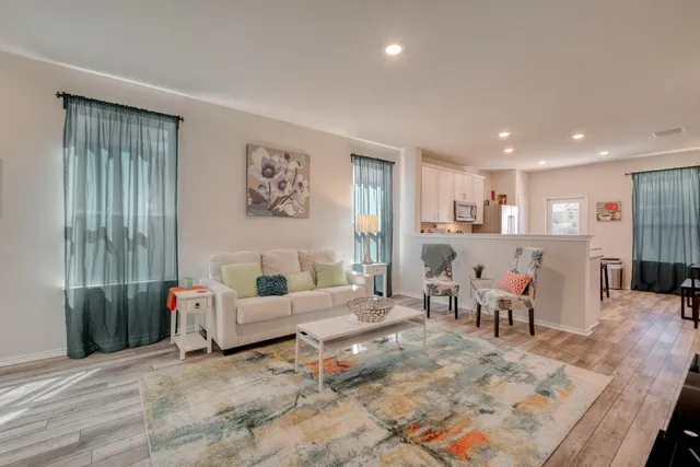 a living room with furniture and a wooden floor