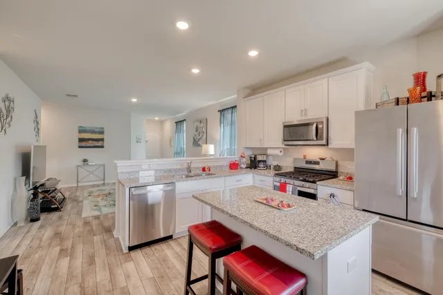 a kitchen that has a sink cabinets and wooden floor