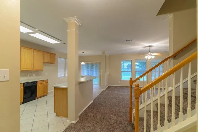 an empty room with fireplace fan and windows