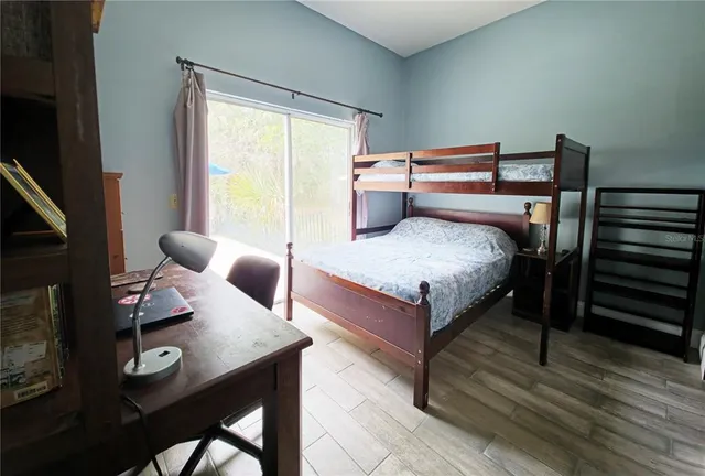 a bedroom with a bed and wooden floor