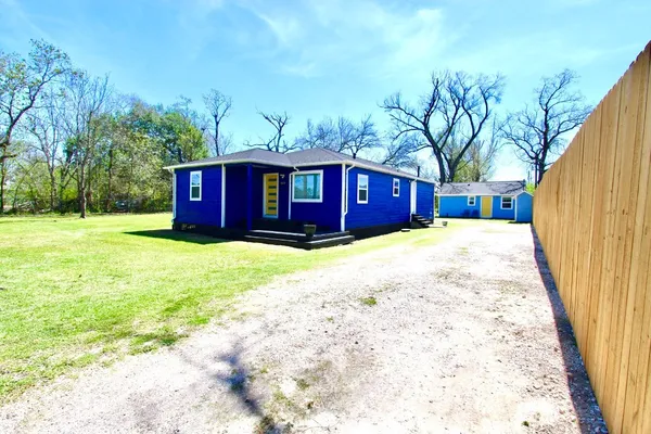 a view of a house with a yard and trees
